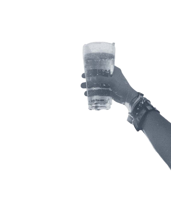 A raised hand holding a glass of beer, black and white